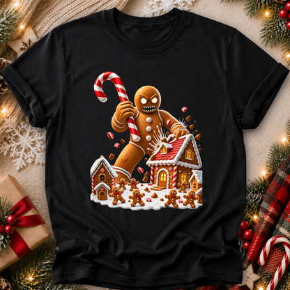 a black tshirt with a graphic design of an evil gingerbread man that is attacking a gingerbread town and other gingerbread people are screaming and running away and he's holding a giant candy cane