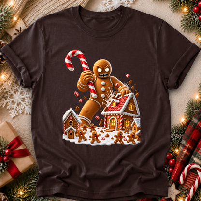 dark brown tshirt with a graphic design of an evil gingerbread man that is attacking a gingerbread town and other gingerbread people are screaming and running away and he's holding a giant candy cane