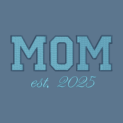Embroidered-style text reading 'MOM est. 2025' in light blue on a muted blue-gray background.