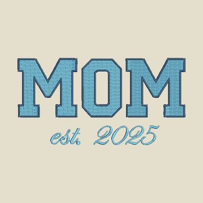 Embroidered-style text reading “MOM” in large blue varsity letters with “est. 2025” below in a matching script, centered on a light beige background.