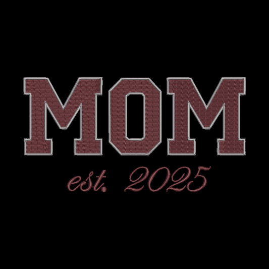 Embroidered-style text reading “MOM est. 2025” in maroon letters with a light outline on a black background.
