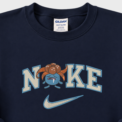 Close-up of a navy blue Gildan sweatshirt featuring a 'NIKE' graphic with a pokemon gloomy cartoon character and a light blue Nike swoosh.