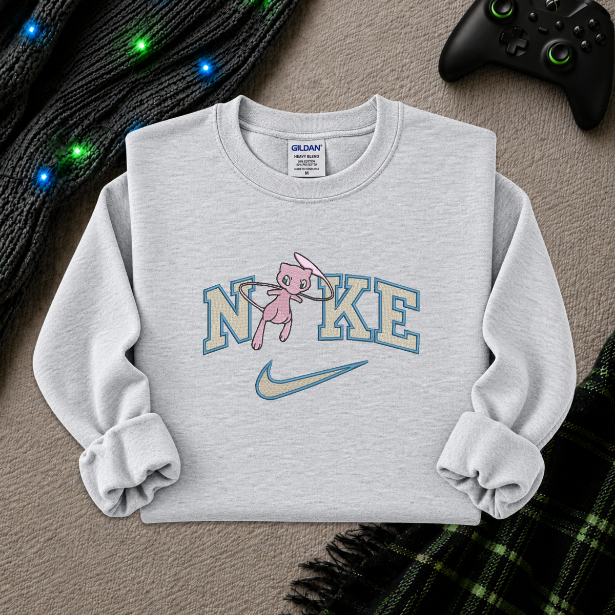 a light ash gray sweatshirt with an embroidered design of a pokemon mew character in the NIKE logo with a swoosh