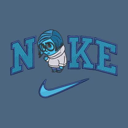 A blue embroidered Nike graphic on a slate blue fabric background, featuring the word 'NIKE' with a cartoon character replacing the 'I' and a Nike swoosh below.