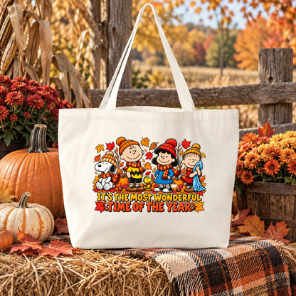 beige canvas tote bag with a graphic of peanuts gang at fall time that says its the most wonderful time of year in an autumn pumpkin setting