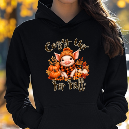 woman wearing a black hoodie with a pig in a scarf with fall pumpkins graphic that says cozy up for fall