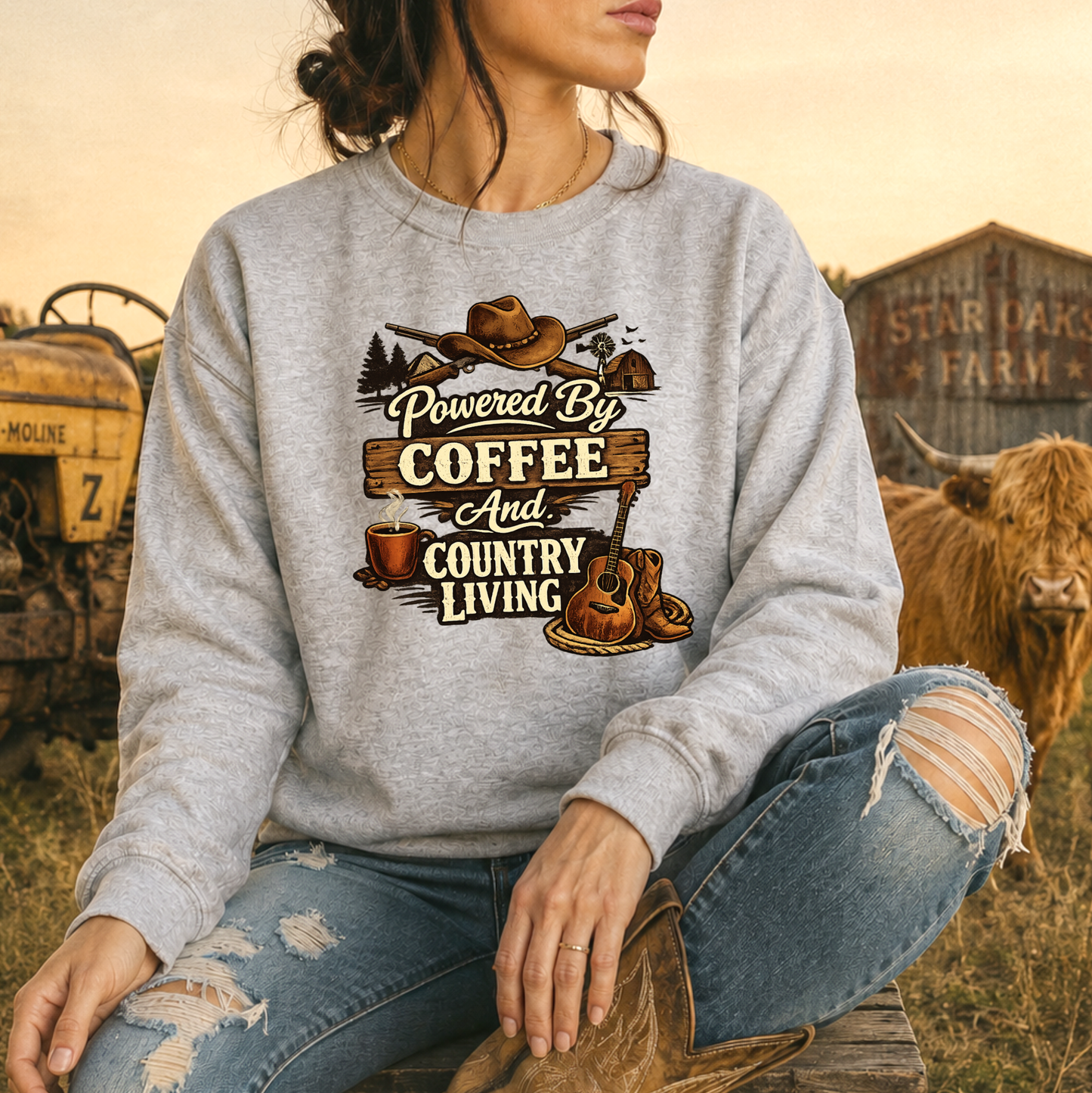 woman wearing a gray sweatshirt with country western style graphic design that says powered by coffee and country living