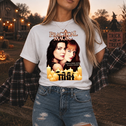 A woman wearing a white graphic T-shirt with a 'Practical Magic' movie print, styled with a black plaid flannel shirt draped off her shoulders and distressed blue jeans, set against a warm, autumnal Halloween-themed background.