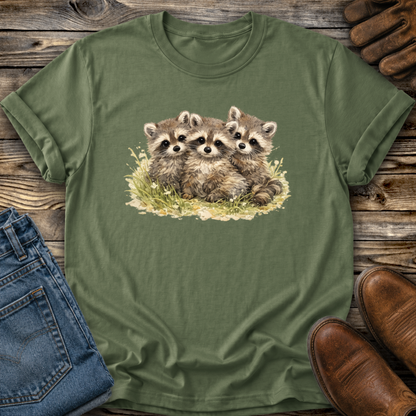green tshirt with a watercolor style graphic of baby raccoons