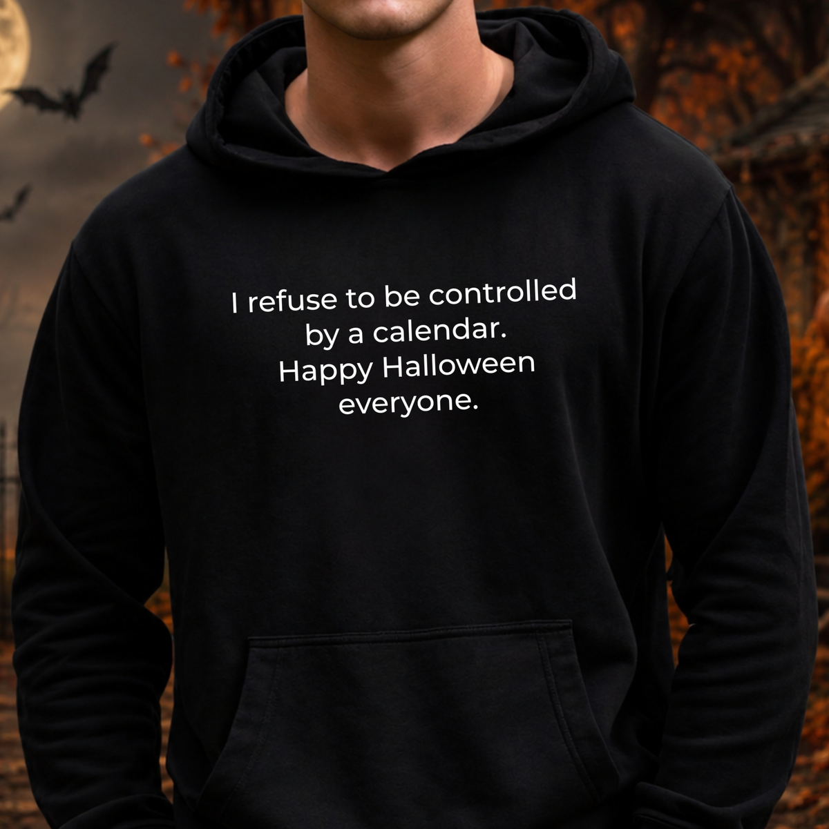 man wearing a black hooded sweatshirt with a text graphic that says I refuse to be controlled by a calendar Happy Halloween everyone