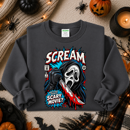 A dark gray crewneck sweatshirt featuring a comic-book style graphic of Ghostface from Scream holding a bloody knife, with the text 'SCREAM' and 'SCARY MOVIE?'. The sweatshirt is displayed in a flat-lay Halloween setting with pumpkins, a candle, and spider decorations.