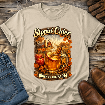 beige tshirt with fall autumn farm scene with a glass of apple cider graphic that says sippin cider down on the farm