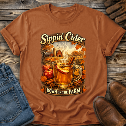 orange tshirt with fall autumn farm scene with a glass of apple cider graphic that says sippin cider down on the farm