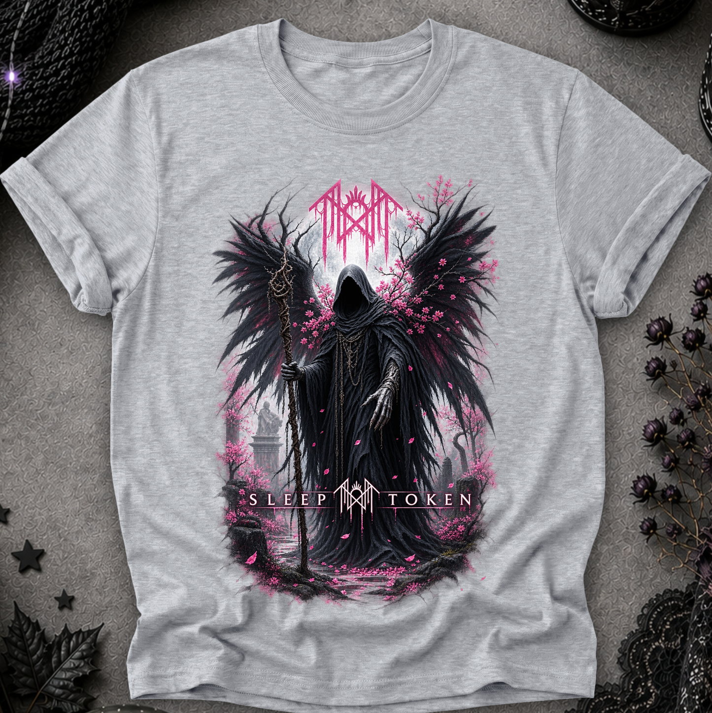 A light heather gray t-shirt featuring a gothic graphic of a hooded grim reaper with large black wings, holding a staff, surrounded by pink petals and the text  'Sleep Token'.