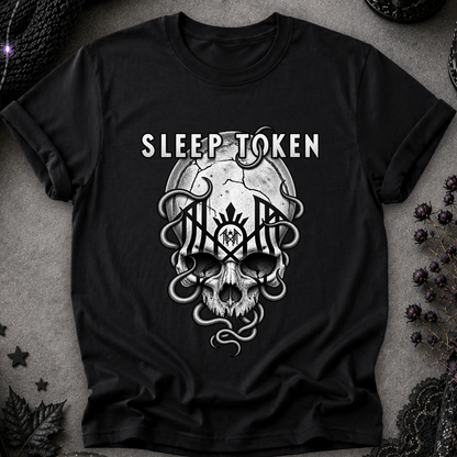 A black short-sleeve graphic t-shirt featuring a white and gray gothic design with the text 'SLEEP TOKEN' above a skull and snake motif, laid flat on a textured gray background with dark decorative props.