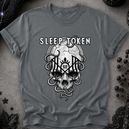 A gray short-sleeve t-shirt with a black and white graphic of a skull, snakes, and the text 'SLEEP TOKEN' laid flat on a textured gray background with dark decorative props.