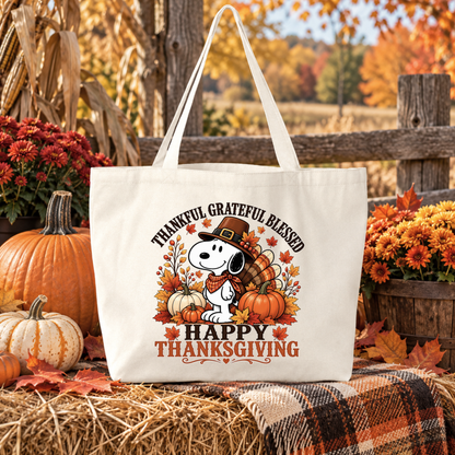 beige canvas tote bag with a graphic of snoopy wearing a pilgrim hat with turkey pumpkins and leaves that says happy thanksgiving and thankful grateful blessed