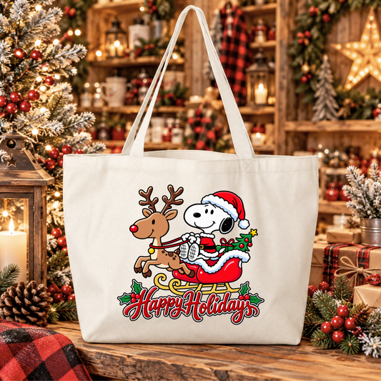 a beige canvas tote bag with a christmas graphic of snoopy riding in santa's sleigh in his costume pulled by a reindeer and says happy holidays