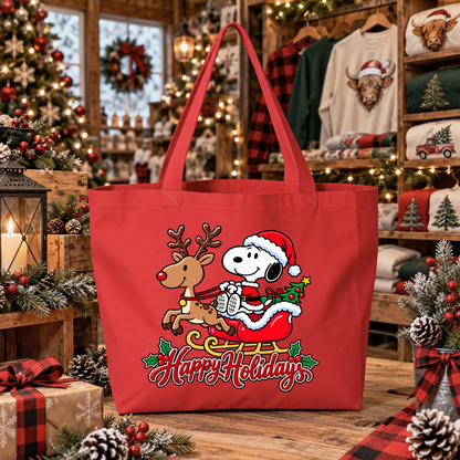 a red canvas tote bag with a christmas graphic of snoopy riding in santa's sleigh in his costume pulled by a reindeer and says happy holidays