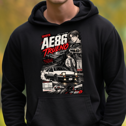 A person wearing a black pullover hoodie with a large graphic print on the front featuring the Toyota AE86 Trueno car, anime-style character art, and racing text, against a blurred outdoor background.