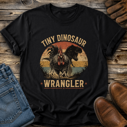 black tshirt with a distressed graphic of a angry chicken and dinosaur that says tiny dinosaur wrangler