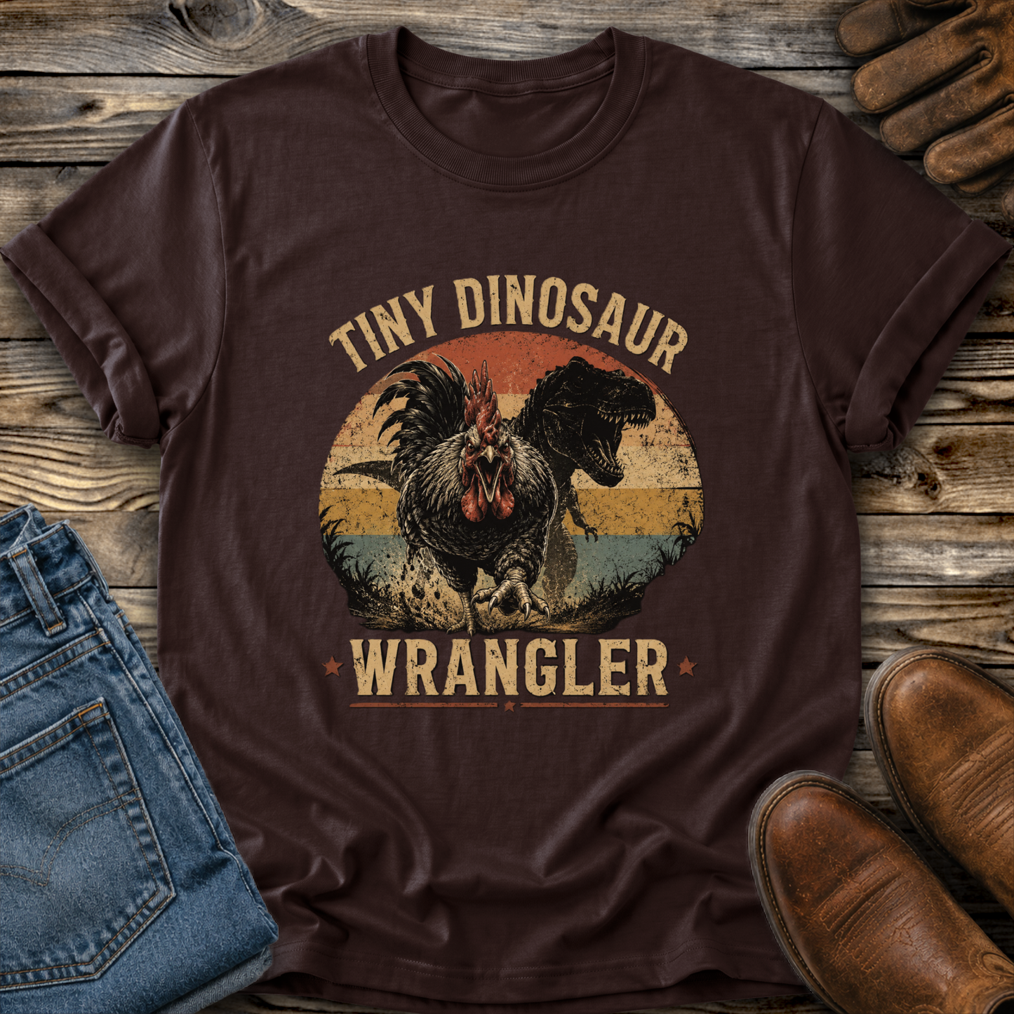 brown tshirt with a distressed graphic of a angry chicken and dinosaur that says tiny dinosaur wrangler
