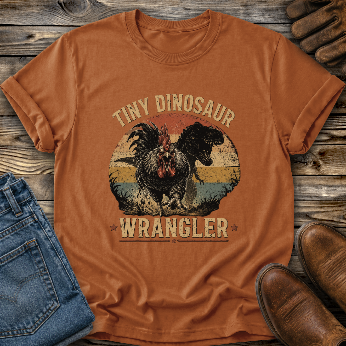 texas orange tshirt with a distressed graphic of a angry chicken and dinosaur that says tiny dinosaur wrangler