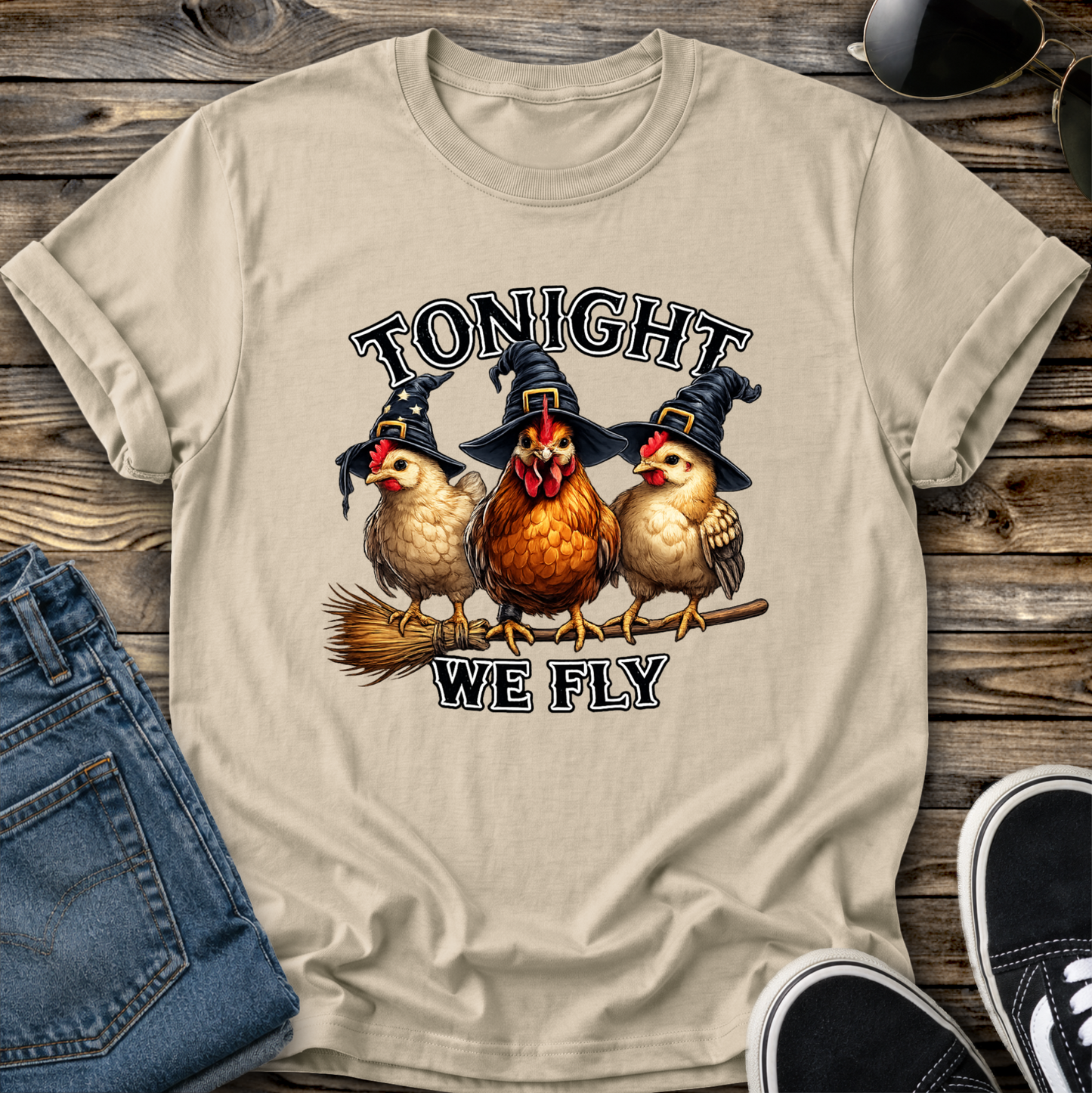 sand tshirt with funny chicken witches on a broomstick graphic design that says tonight we fly