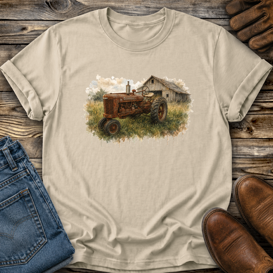 beige tshirt with a watercolor barn and rusty farmall tractor farm scene graphic on it