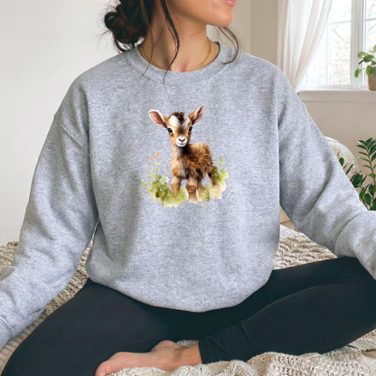woman wearing a gray sweatshirt with a watercolor style baby goat graphic on it