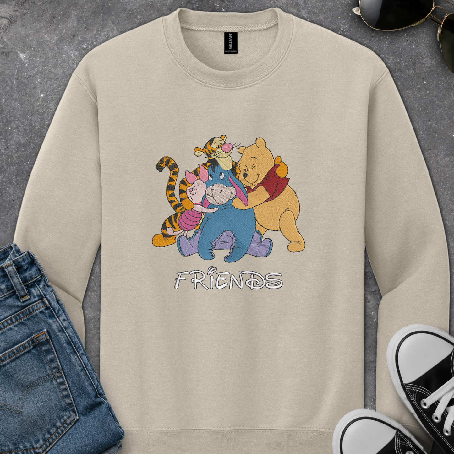 beige sweatshirt with an embroidered design of winnie the pooh friends