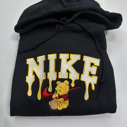 black sweatshirt with embroidered winnie the pooh with honey dripping from the nike logo