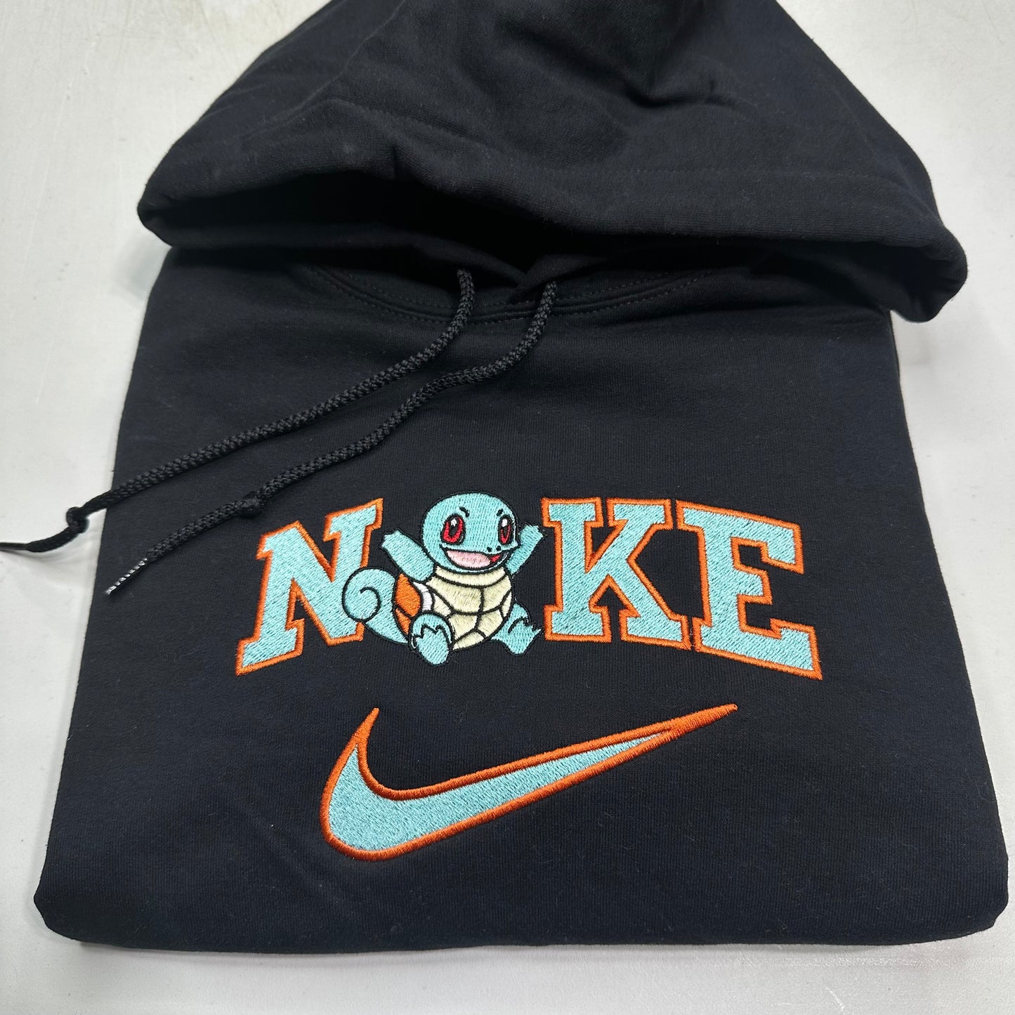 pokemon squirtle with nike logo embroidered on a black sweatshirt