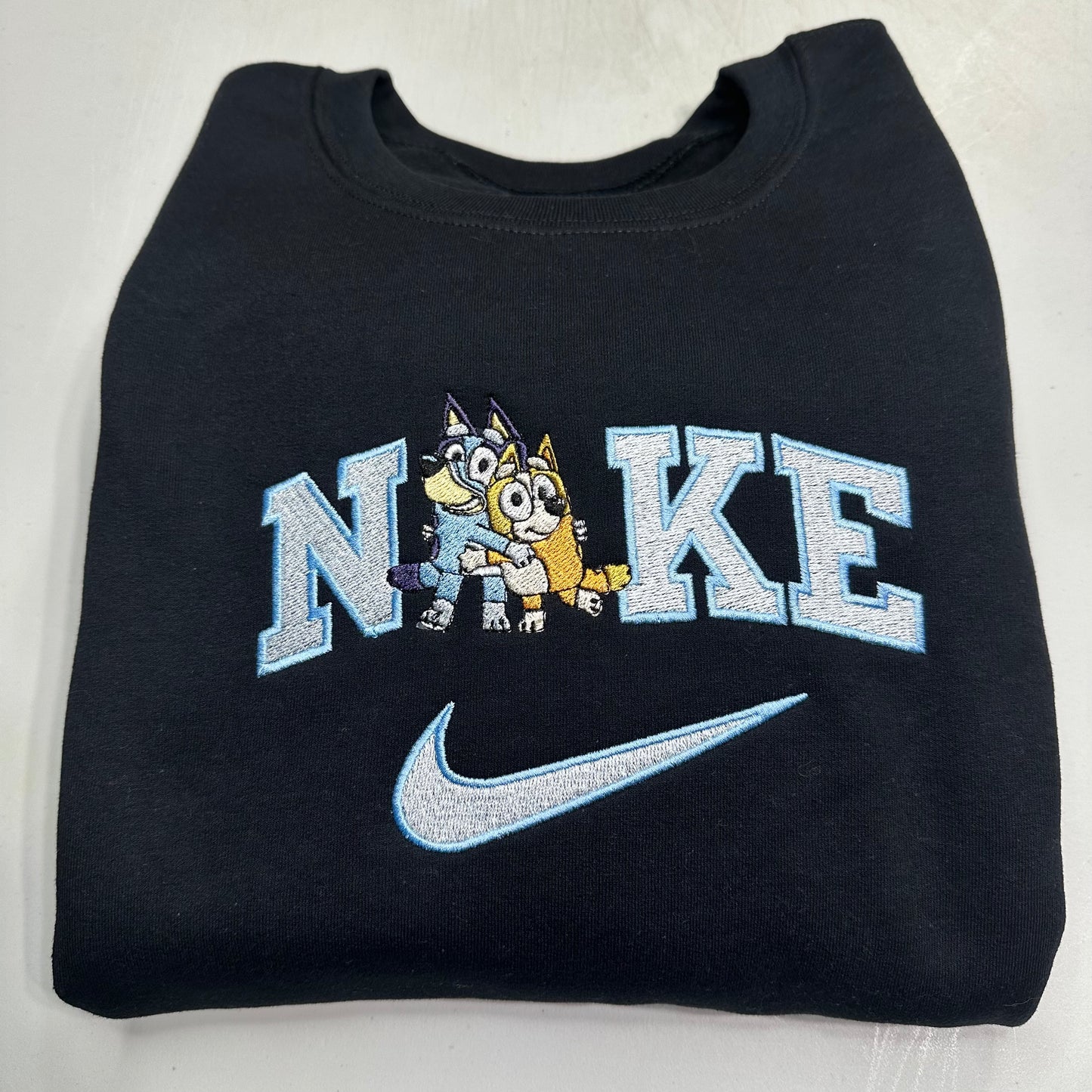 black sweatshirt with nike logo and cartoon character on it
