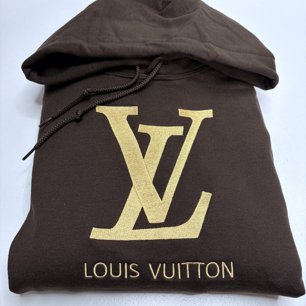 dark brown sweatshirt with a gold embroidered louis vuitton logo