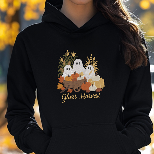 woman wearing a black sweatshirt with a fall season embroidered design of ghosts, pumpkins and leaves.