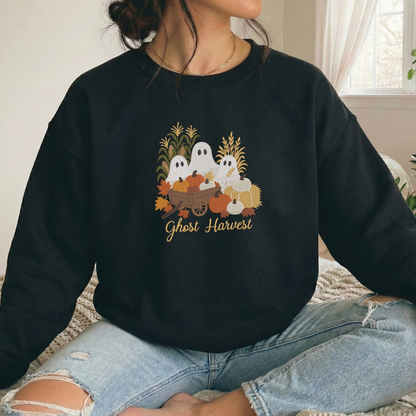 A person wearing a black crewneck sweatshirt with a 'Ghost Harvest' graphic on the front, paired with light-wash ripped jeans, sitting indoors.