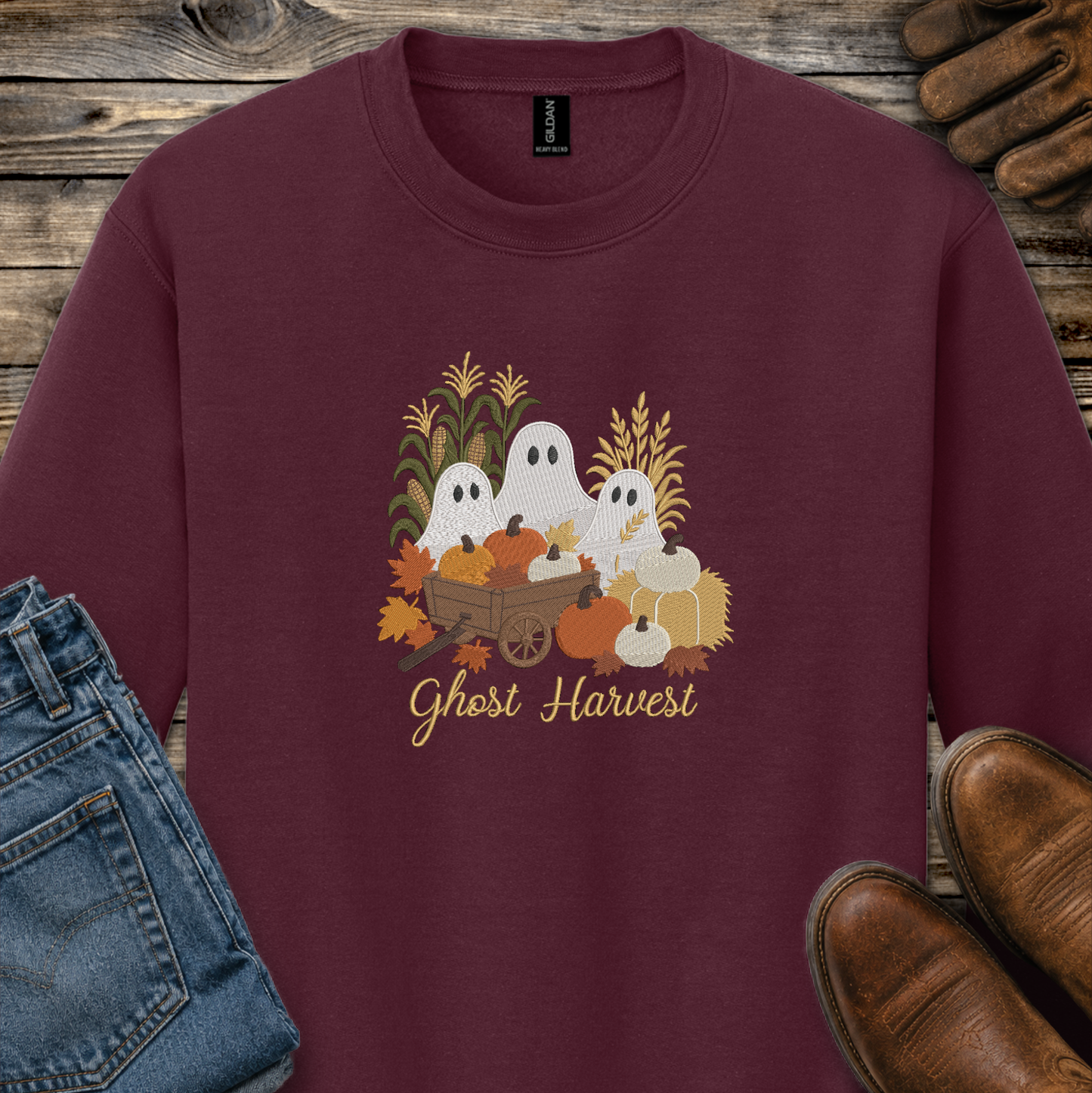maroon sweatshirt with a fall season embroidered design of ghosts, pumpkins and leaves.
