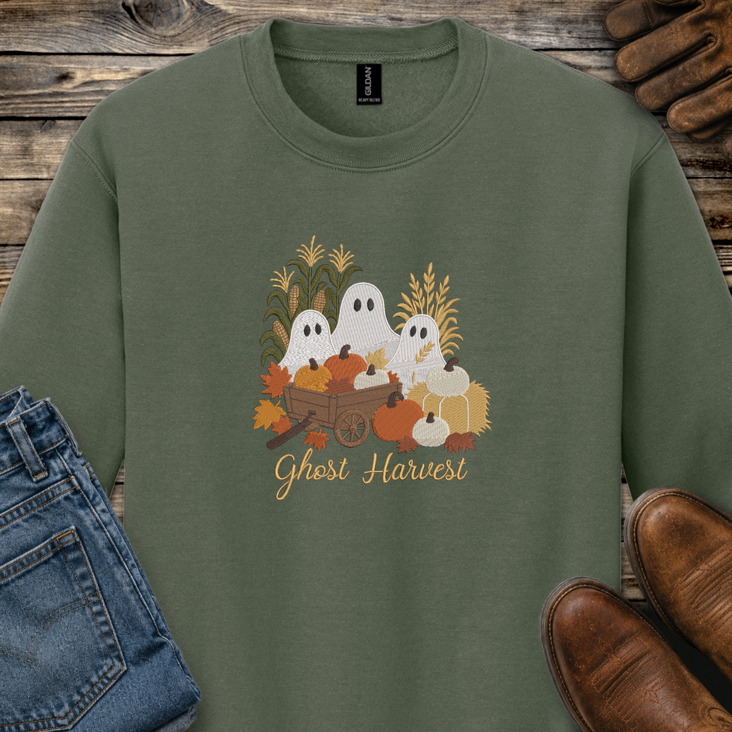 green sweatshirt with a fall season embroidered design of ghosts, pumpkins and leaves.