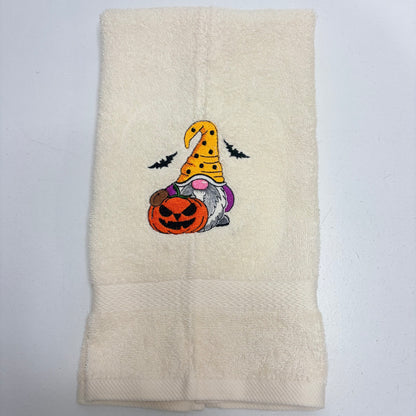 beige towel with an embroidered fall halloween gnome design on it