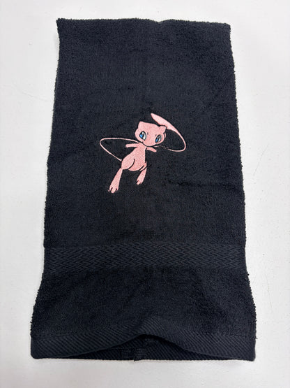 black towel with pokemon mew character embroidered on it