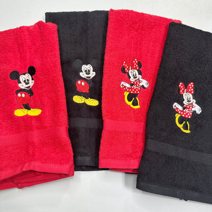 Four folded towels arranged in a fan shape on a light gray background, alternating between red and black, each embroidered with a Mickey Mouse or Minnie Mouse character design.