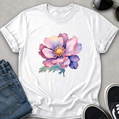 A white short-sleeve crewneck t-shirt featuring a colorful watercolor-style anemone flower graphic on the front. The shirt is styled in a flat-lay arrangement with blue jeans, black sneakers, and sunglasses on a light gray textured background.