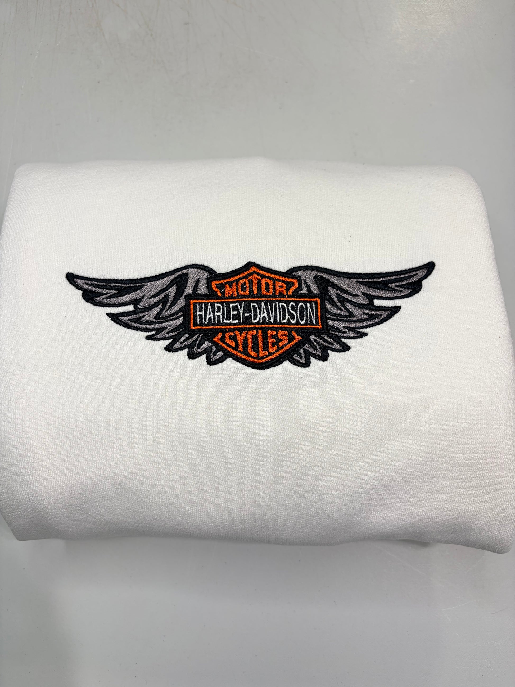 White sweatshirt with a Harley-Davidson logo on a mannequin against a gray background